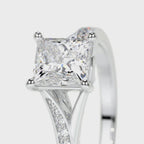 Close-up of double corner prongs and pave diamond split shoulder on a white gold princess cut ring.