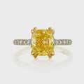 Top-down view of a 2 carat fancy yellow cushion cut lab diamond with double claw prongs and a diamond pavé shank.