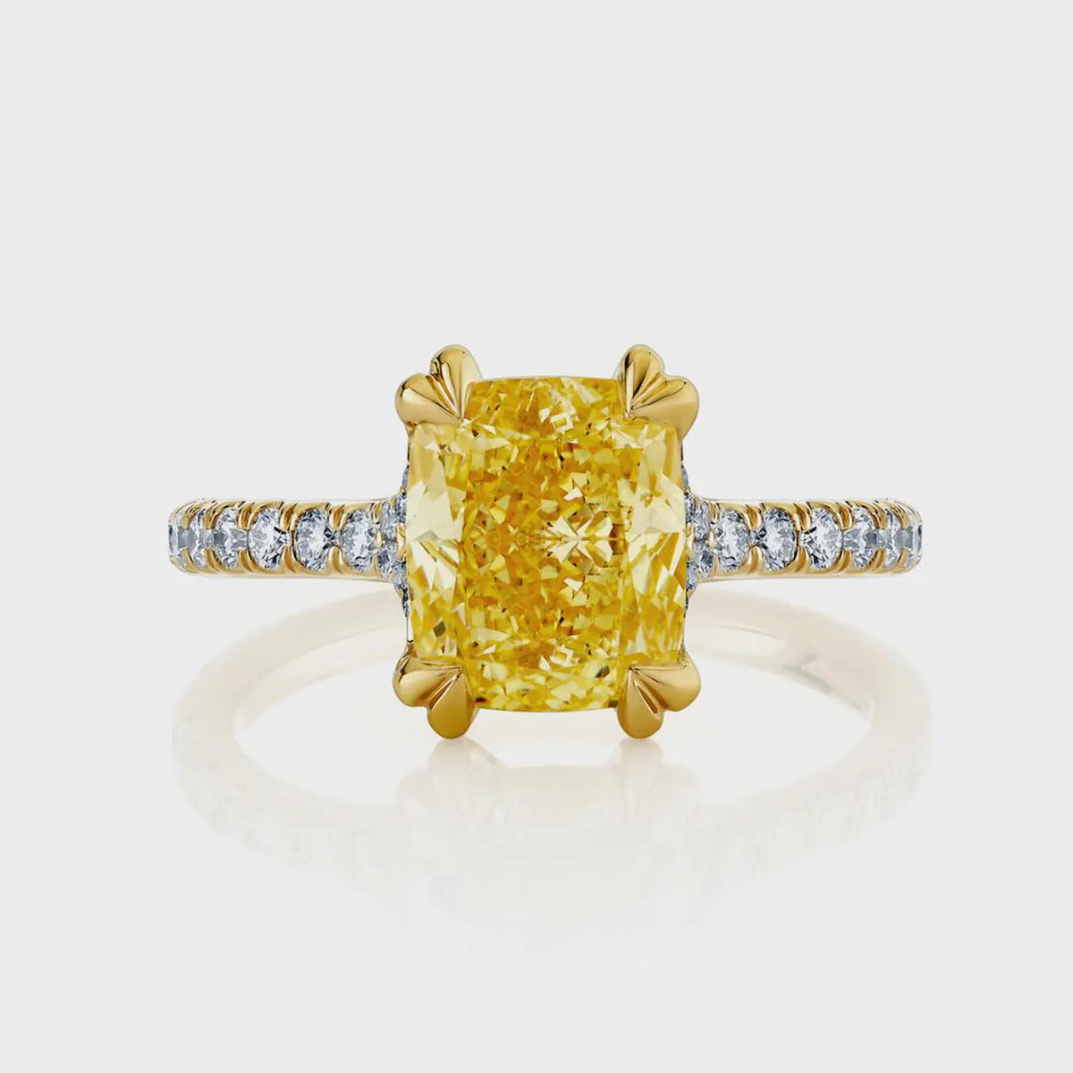 Top-down view of a 2 carat fancy yellow cushion cut lab diamond with double claw prongs and a diamond pavé shank.