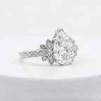 Side angled profile of a 3 carat pear cut lab diamond engagement ring in white gold featuring floral side detail.