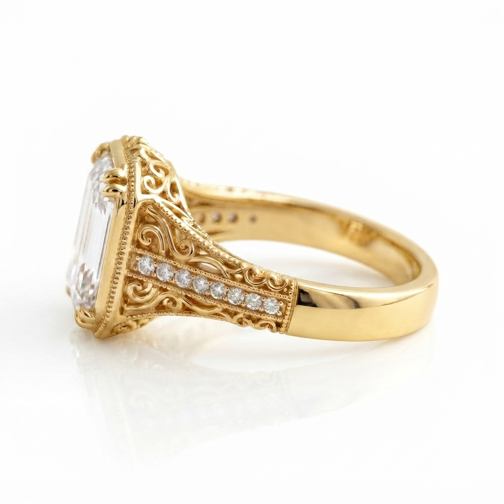 Side profile of a 5 CT emerald cut lab grown diamond ring in yellow gold highlighting the openwork filigree band and pave channel.
