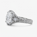 Side profile of a white gold 3 CT cushion cut lab diamond ring showing detailed scrollwork and floral hand engraving along the band.