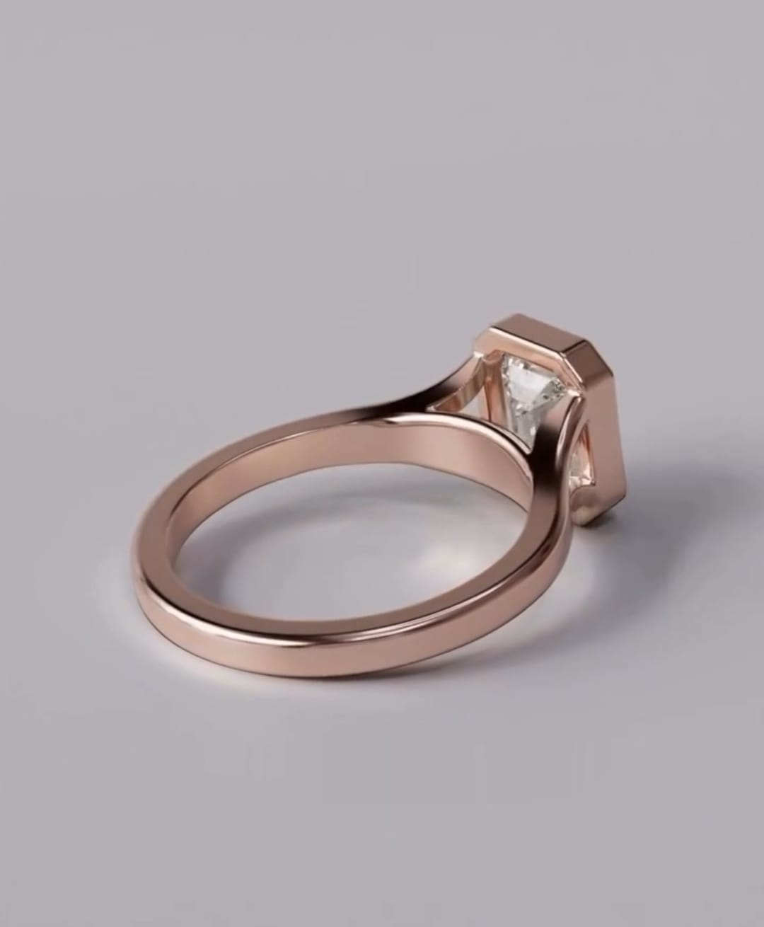 Side profile view of a rose gold bezel set engagement ring showcasing a 3 CT emerald cut lab-grown diamond with architectural under-gallery detail.