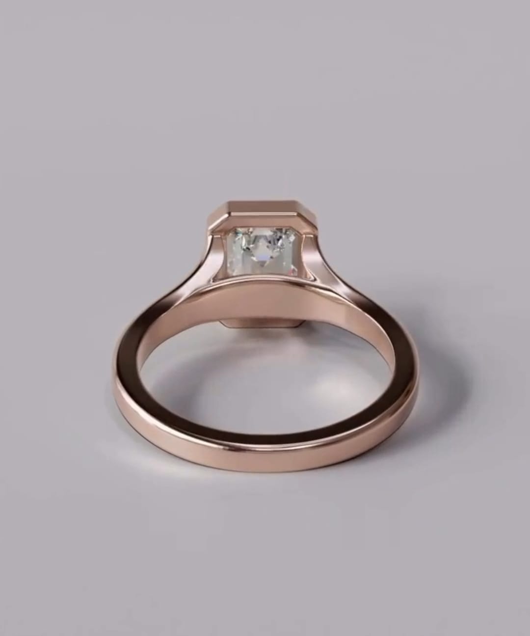View through the polished rose gold band showing the secure back bezel setting holding an emerald cut lab diamond.