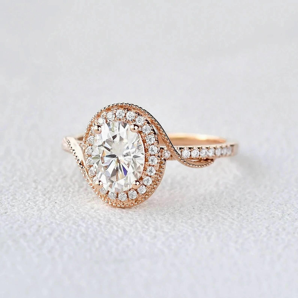 Detailed studio close-up of a rose gold bypass ring with a 2 CT oval lab diamond center and pavé-accented swirl band.