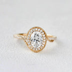 Centered front studio shot of the 2 carat oval lab grown diamond ring with vintage milgrain halo on a light background.