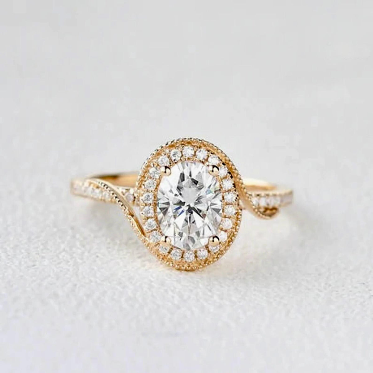 Centered front studio shot of the 2 carat oval lab grown diamond ring with vintage milgrain halo on a light background.