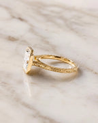 Side perspective view of a 4 CT radiant cut lab grown diamond engagement ring in yellow gold with hand-engraved scrollwork shank.
