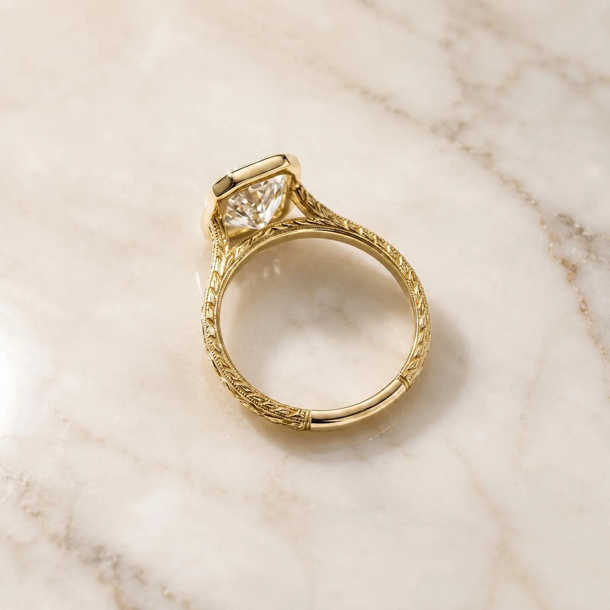 Full profile view illustrating the continuous vintage engraved pattern on the yellow gold band and undercarriage bezel setting.