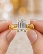Close-up view of hands holding the 4 carat emerald cut lab grown diamond vintage engagement ring.