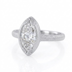 Angled perspective view of a 4 CT marquise cut lab grown diamond ring in matte white gold featuring leaf-engraved bezel tips.