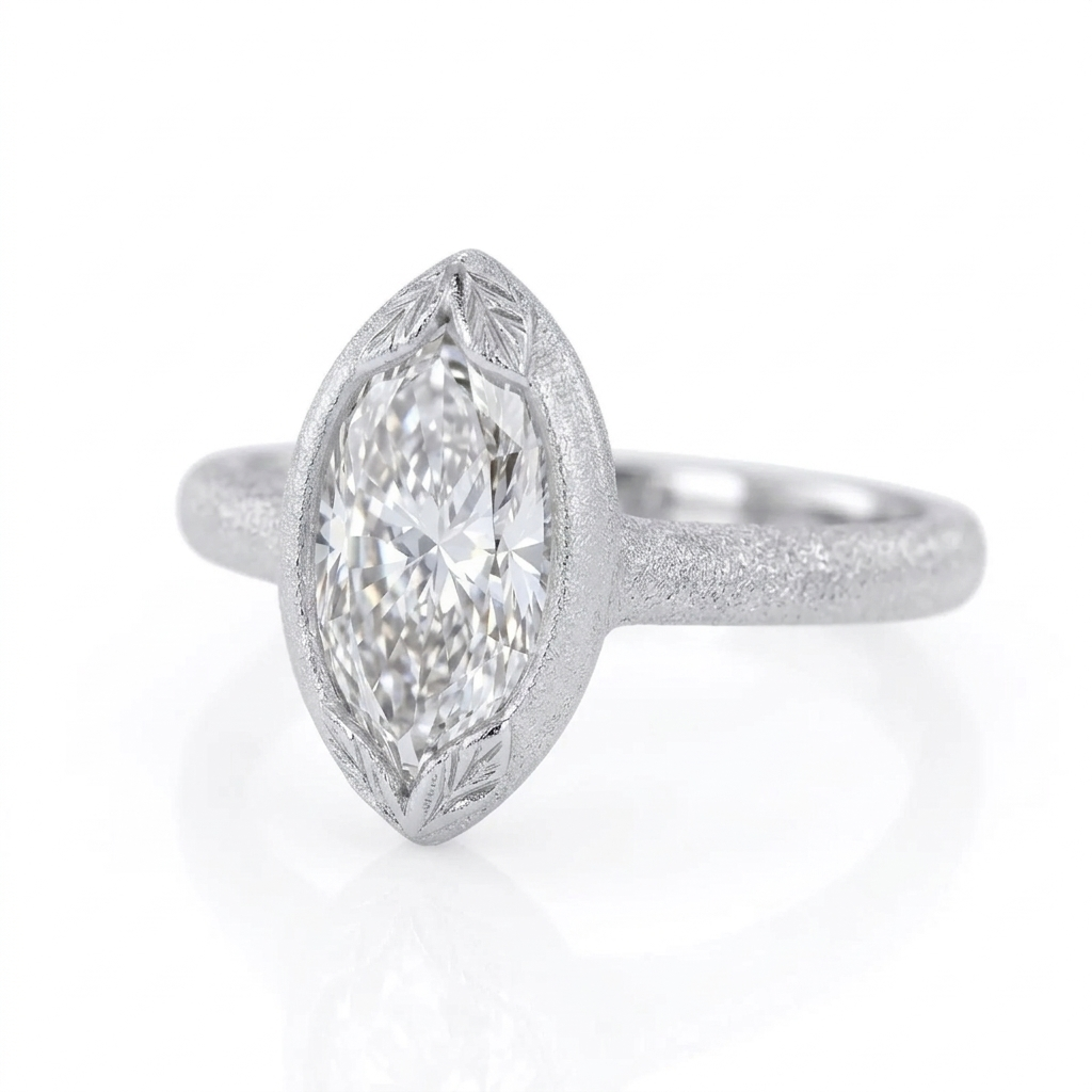 Angled perspective view of a 4 CT marquise cut lab grown diamond ring in matte white gold featuring leaf-engraved bezel tips.