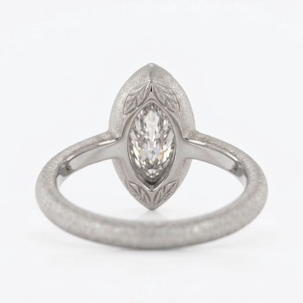 Back and profile view showing the inner smooth band and matte outer texture of a white gold marquise diamond bezel ring.
