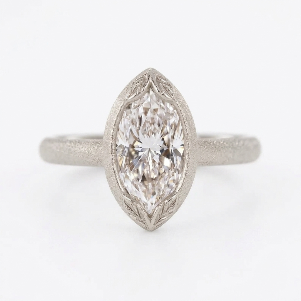 Centered top view of a 4 carat marquise cut lab grown diamond in a matte white gold bezel frame with leaf engravings.