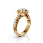 Side profile view of a yellow gold vintage round diamond halo ring displaying intricate leaf scrollwork under-gallery and milgrain edge.