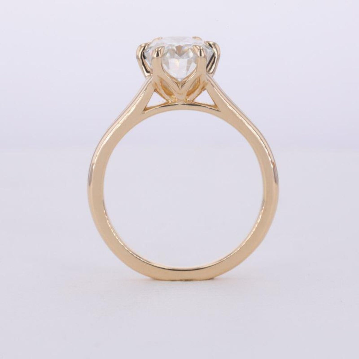 Profile view of a 3 carat oval lab grown diamond cathedral ring in 14K yellow gold.