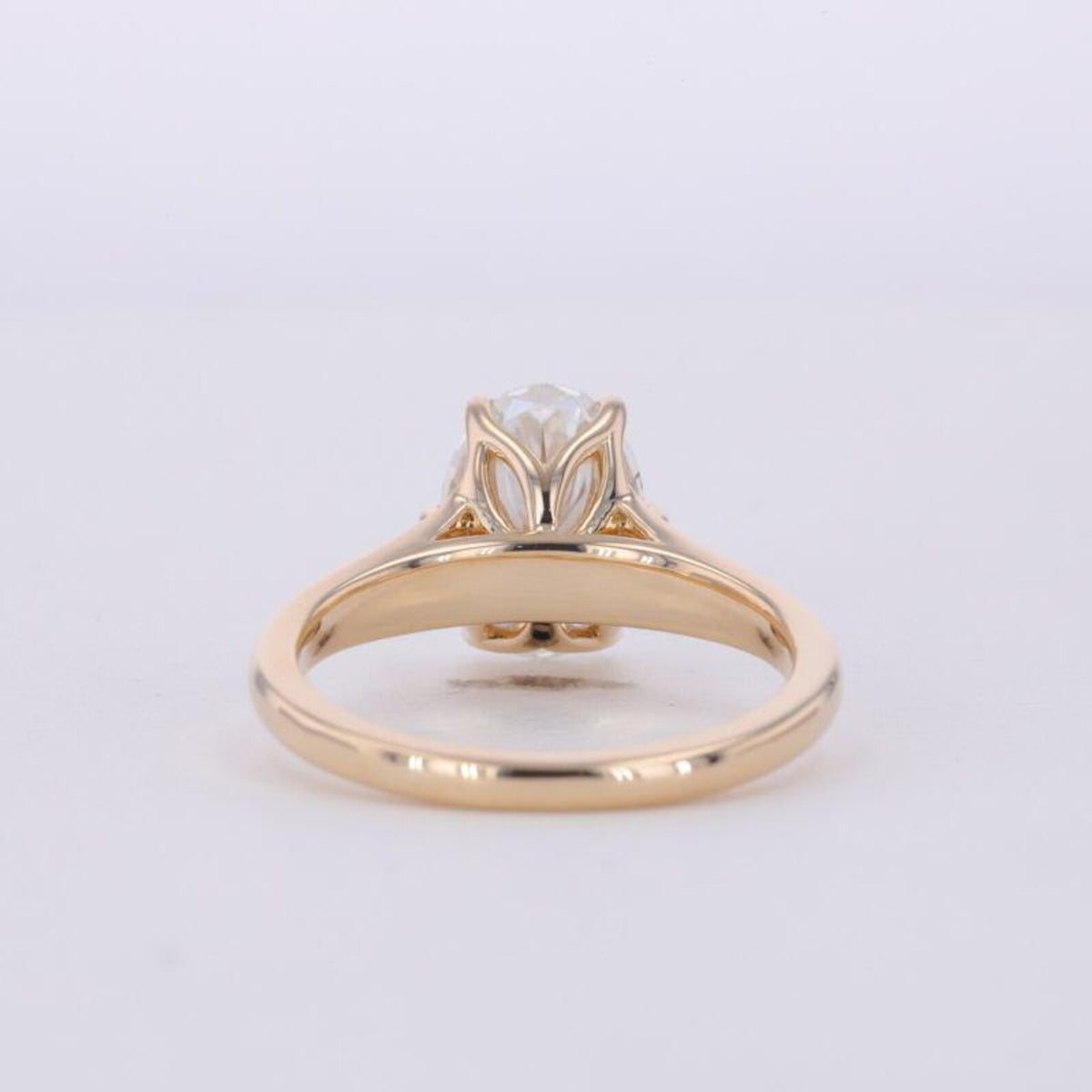 Bottom angle view showing the sculpted petal basket and shank of a 3 CT oval diamond ring.