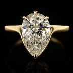 Front view of a 3 CT pear cut lab-grown diamond solitaire set in five protective yellow gold prongs on a minimal band.