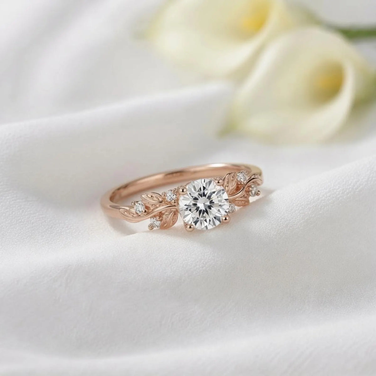 3 CT round cut lab grown diamond nature-inspired engagement ring with botanical leaf accents in rose gold on white fabric.