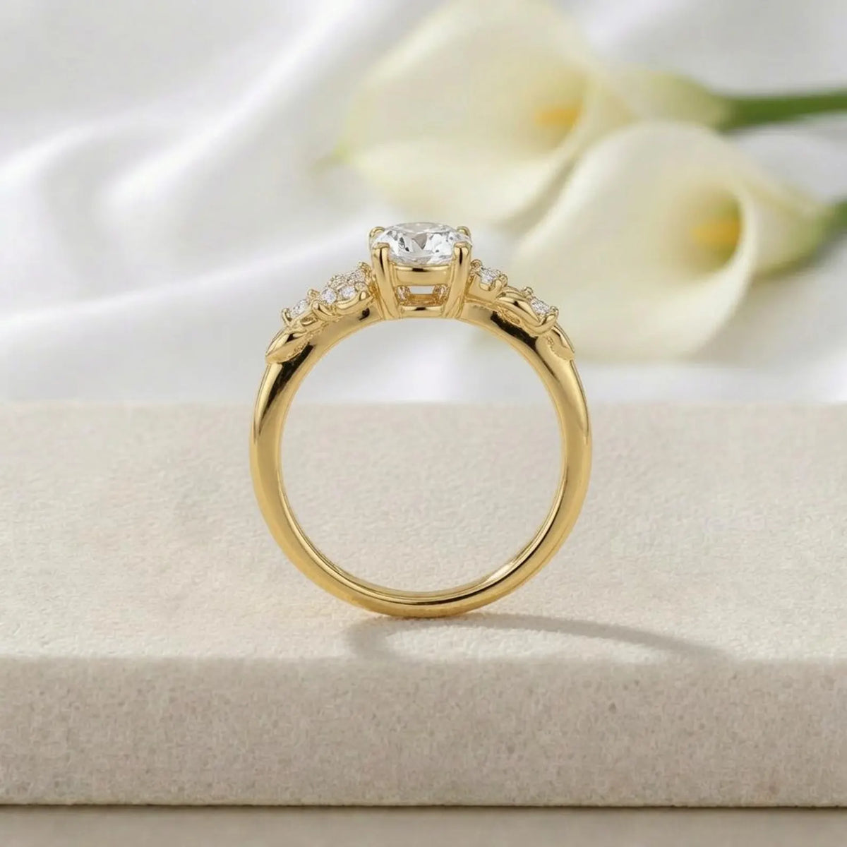 Side profile view of a 3 CT round lab grown diamond botanical leaf ring resting on a stone display in yellow gold.