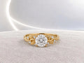 Studio top view showing a 3 CT round lab grown diamond set in a yellow gold band with sculpted leaf shoulders.