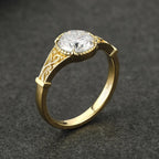 Side angle view of an 18K yellow gold 3 CT round lab grown diamond ring with openwork scroll details.