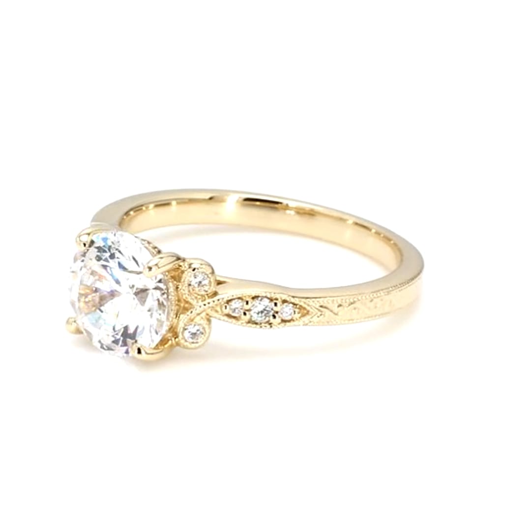 Perspective view of a 3 CT round lab grown diamond engagement ring with vintage hand engraving in yellow gold.