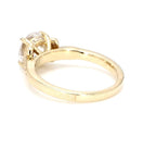 Angled back view of a yellow gold vintage engagement ring featuring hand engraving and a 3 CT round lab grown diamond.