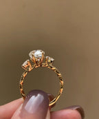 Side profile view showing the basket gallery, pear side stones, and twisted band of a 2 CT oval lab diamond ring.