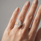 Hand shot displaying a dramatic 4 CT marquise cut lab grown diamond solitaire ring creating light flares.