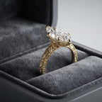 Side angle of a 4 CT marquise lab diamond ring in a velvet box displaying hand-engraved band and milgrain borders.