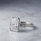 Side view of a 3 CT radiant lab grown diamond engagement ring in white gold featuring a half bezel setting and scrollwork band.