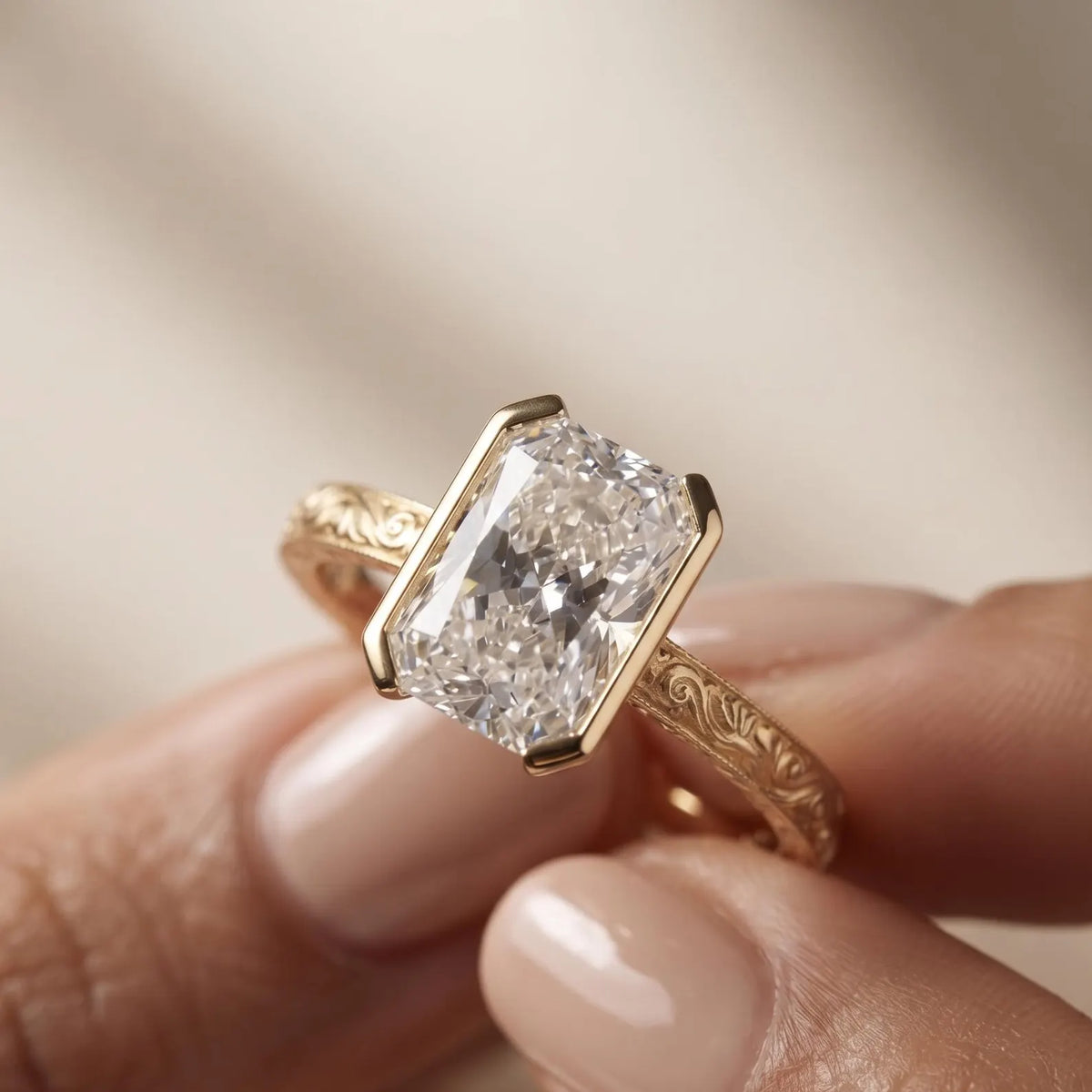 Detailed hand shot of a 3 CT radiant cut lab grown diamond yellow gold half bezel solitaire ring with milgrain details.