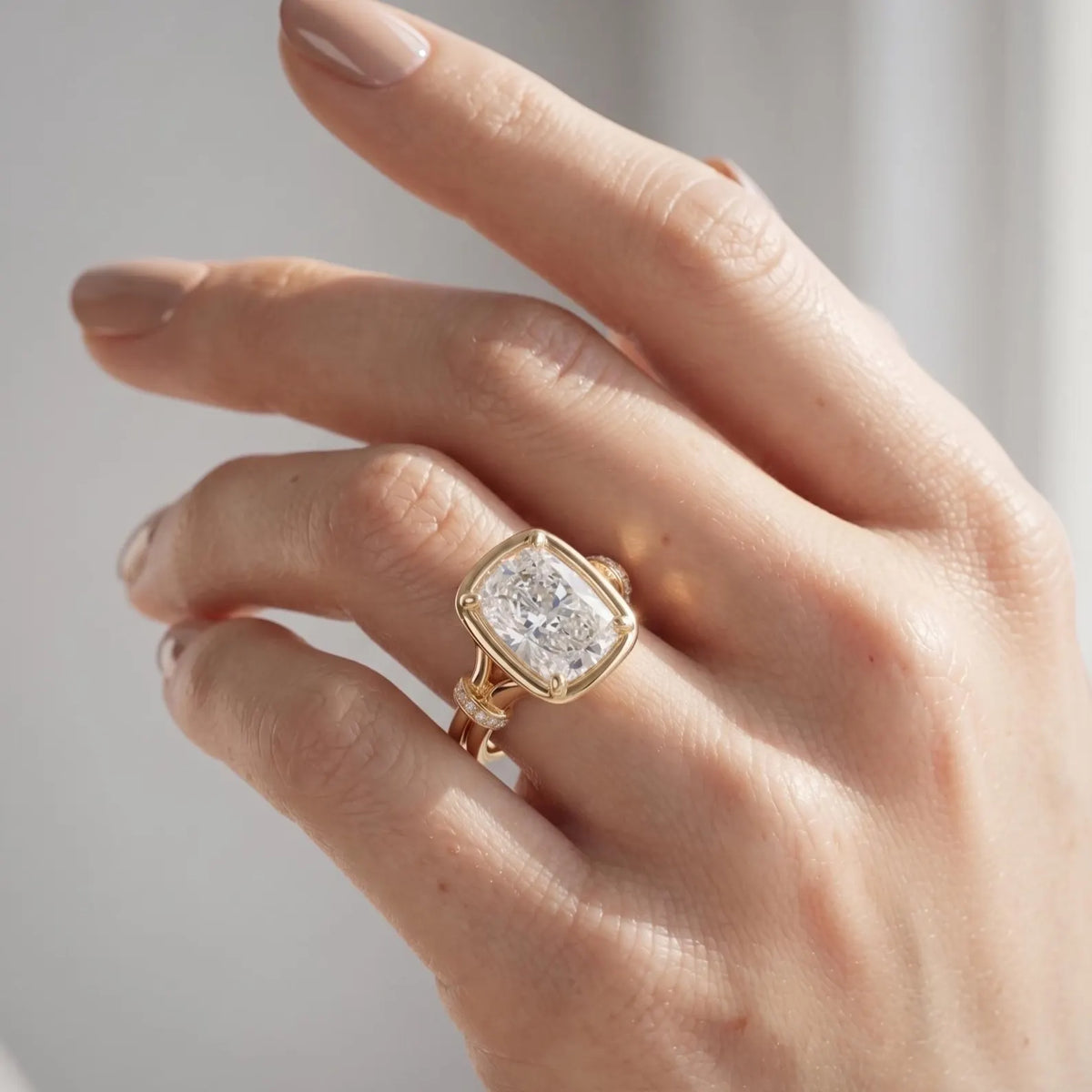 On-finger view of a 3 CT cushion cut lab diamond engagement ring in 14K yellow gold under direct natural sunlight.