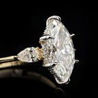 Close-up side perspective showing the six-prong platinum/white gold head, protective V-prongs, and a delicate pave diamond hidden halo surrounding the marquise center stone.