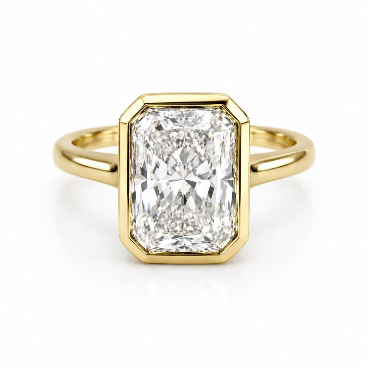 Top-down view of a 4 CT elongated radiant cut lab grown diamond ring framed in a yellow gold full bezel setting.