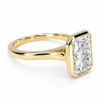 Low three-quarter view highlighting the high-polish yellow gold shank and bezel setting on a 4 CT radiant ring.