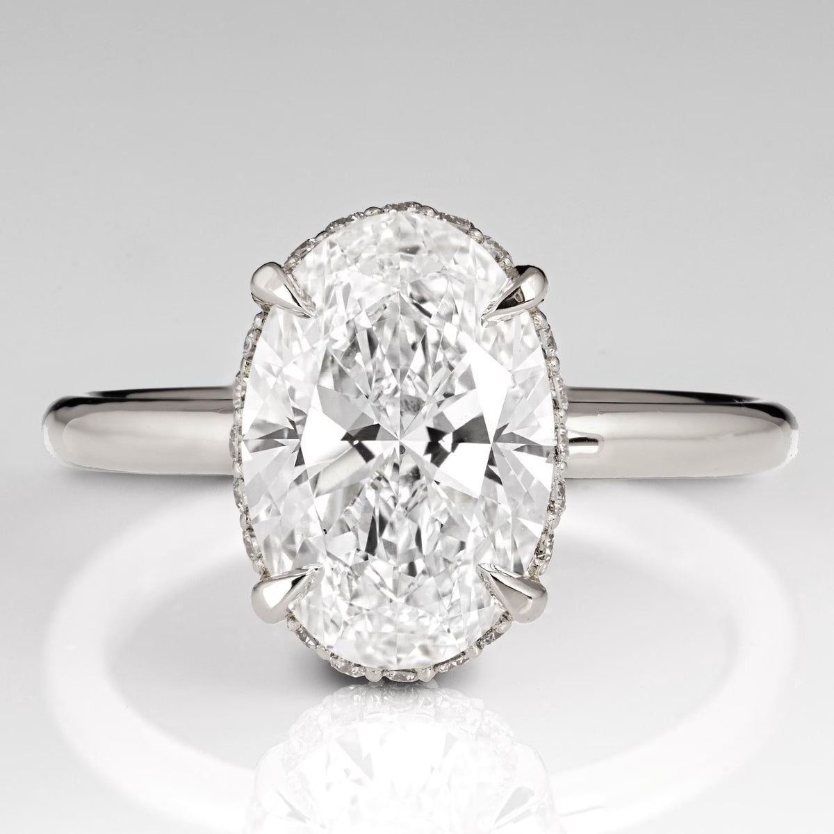 Top view of a 3 CT oval cut lab grown diamond engagement ring with claw prongs in white gold.