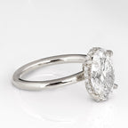 Side angle view of a 3 CT oval lab diamond ring showing micro-pave hidden halo collar and claw prongs.
