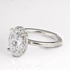 Angled view displaying the 3 CT oval lab grown diamond with delicate claw prongs and hidden halo.