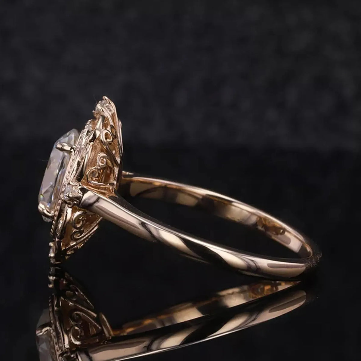 Side profile view of a 3 CT oval cut lab grown diamond ring with carved filigree halo setting in yellow gold.