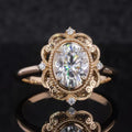 Direct top view of a 3 CT oval cut lab grown diamond surrounded by an ornate milgrain filigree halo on a polished gold band.