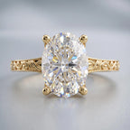 Close-up front view of an elongated 3 CT oval cut lab grown diamond set in a vintage engraved yellow gold band.