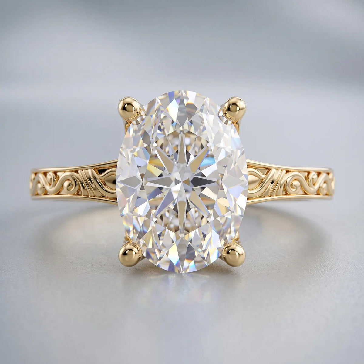 Close-up front view of an elongated 3 CT oval cut lab grown diamond set in a vintage engraved yellow gold band.