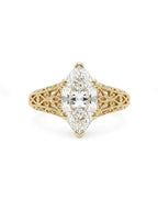 Direct top view of a 4 CT marquise cut lab grown diamond set in a 6-prong vintage filigree yellow gold ring.