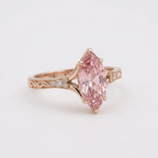 Angled view highlighting shoulder diamond accents and fancy pink marquise center diamond.
