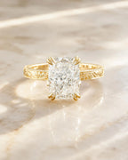 Front view of a 3 CT elongated cushion cut lab grown diamond ring resting on a marble surface.