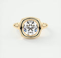 Top-down view of a 3 CT round lab grown diamond set in a yellow gold cushion bezel frame.