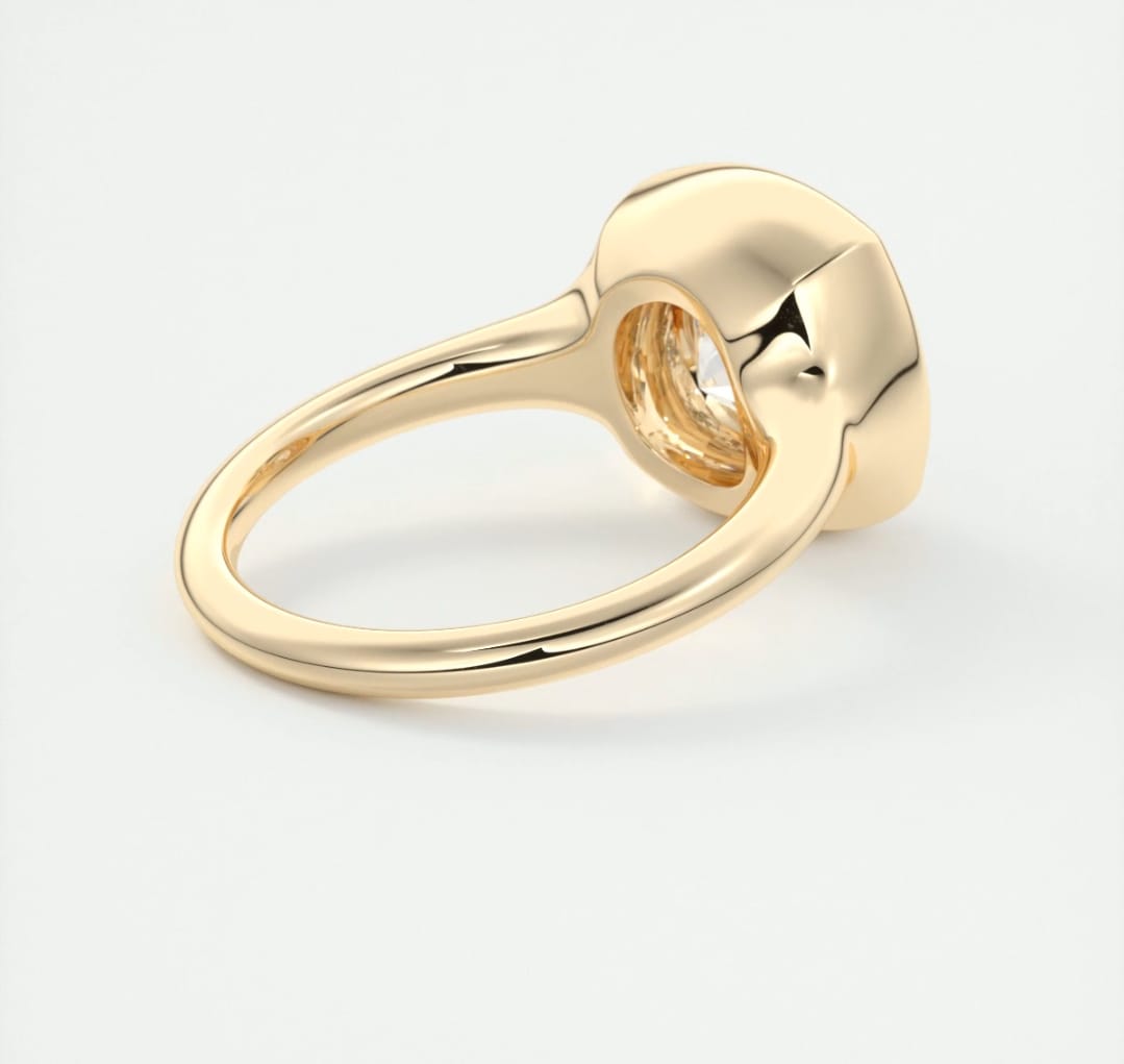Side perspective of the polished 14K yellow gold band tapering into a full bezel ring head.