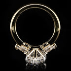 A yellow gold ring with a large clear center diamond and smaller diamonds set in a silver-colored pavé band, shown against a solid black background.